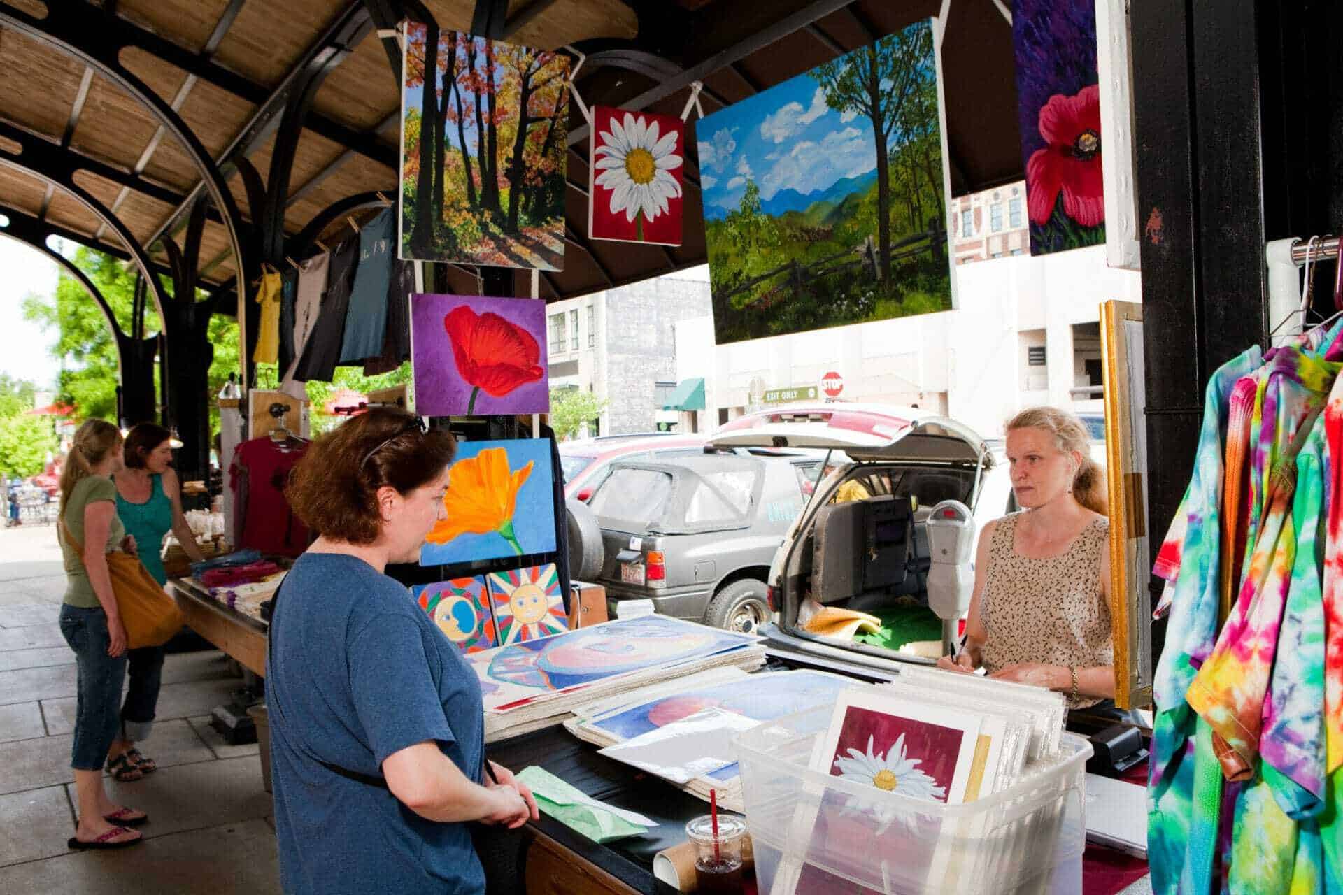 A woman at the art booth at the Makers Market