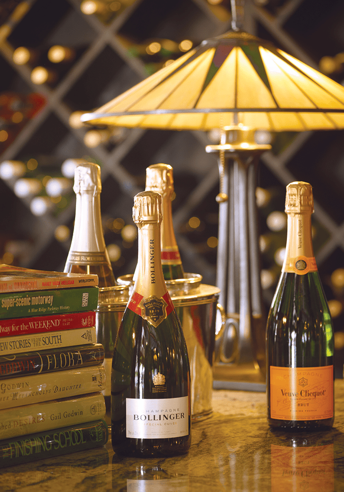 stack of books next to champagne at battery park book exchange in grove arcade