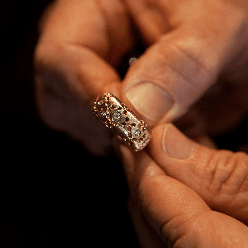 jewelry expert looking at a valuable ring from roberto coin in grove arcade