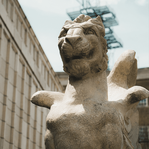 a medium shot of a winged lion that sits outside the north entrance of the grove arcade
