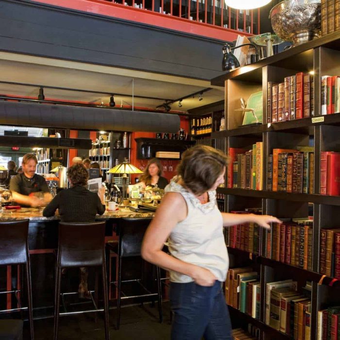 A woman browsing a bookshelf at the Battery Park Book Exchange